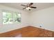Sun-filled bedroom with hardwood floors and large windows offering views of the landscaped yard at 4361 Applegate Rd, Charlotte, NC 28209
