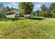 Large backyard with lush green grass, mature trees providing shade and a view of the home at 4405 Sugar Cane Ct, Waxhaw, NC 28173