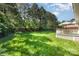 Spacious backyard with lush green grass, bordered by mature trees, and a deck for outdoor entertaining at 4405 Sugar Cane Ct, Waxhaw, NC 28173