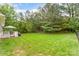 Expansive backyard featuring a well-maintained lawn, a deck with outdoor seating, and surrounded by mature trees at 4405 Sugar Cane Ct, Waxhaw, NC 28173