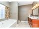 Bathroom featuring a soaking tub, a large vanity, and a window for natural light at 4405 Sugar Cane Ct, Waxhaw, NC 28173