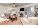 Bright living room featuring large windows with decorative curtains, plush seating, and a ceiling fan at 4405 Sugar Cane Ct, Waxhaw, NC 28173