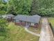 This aerial shot shows a brick house with a long driveway, surrounded by a green lawn and mature trees at 4553 Morgan St, Charlotte, NC 28208