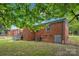 This backyard features a brick house, green lawn, and access stairway in a residential neighborhood at 4553 Morgan St, Charlotte, NC 28208