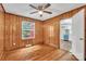 This bedroom features wood paneling, hardwood floors, and a ceiling fan at 4553 Morgan St, Charlotte, NC 28208
