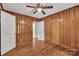 This bedroom features wood paneling, hardwood floors, a ceiling fan, and 2 closets at 4553 Morgan St, Charlotte, NC 28208