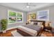 This bedroom features hardwood floors, a ceiling fan, and two windows that offer natural light at 4553 Morgan St, Charlotte, NC 28208
