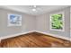 This bedroom features hardwood floors, a ceiling fan, and two windows that offer natural light at 4553 Morgan St, Charlotte, NC 28208