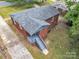 An aerial of the brick house with a small back porch, stairs, and paved driveway at 4553 Morgan St, Charlotte, NC 28208