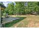 Expansive backyard featuring a stone patio, dining set, and mature trees, ideal for outdoor enjoyment at 4608 Rockwood Dr, Waxhaw, NC 28173