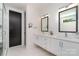Bright bathroom featuring a double sink vanity with modern fixtures, a black door, and a glass shower enclosure at 4608 Rockwood Dr, Waxhaw, NC 28173