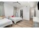 Clean bedroom with hardwood floors, two beds, ceiling lights, and a view into the bathroom at 4608 Rockwood Dr, Waxhaw, NC 28173