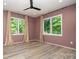 Bedroom featuring hardwood floors, tan walls, two windows with a view to greenery at 4608 Rockwood Dr, Waxhaw, NC 28173