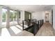 Hallway featuring modern railings, an ornate chandelier, and natural light through large glass doors to an outdoor balcony at 4608 Rockwood Dr, Waxhaw, NC 28173