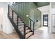 Modern staircase with black handrails, wood steps, and a striking green accent wall in the entryway at 4608 Rockwood Dr, Waxhaw, NC 28173