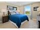 Bedroom showcasing a large bed with blue bedding, complemented by modern furniture and a scenic view from the window at 511 Lenswood Ct, Denver, NC 28037
