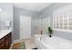 Bathroom with a standalone tub, glass door shower, and white tiled flooring at 52538 Winchester St, Fort Mill, SC 29707