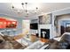 Inviting living room features a cozy fireplace, plush leather sofa, and an open layout to the adjacent kitchen at 52538 Winchester St, Fort Mill, SC 29707
