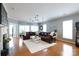 Spacious living room features hardwood floors, plush rug, large windows, and a cozy fireplace at 52538 Winchester St, Fort Mill, SC 29707