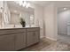 Neutral bathroom with double sinks, gray cabinetry and modern fixtures at 6037 Guildford Hill Ln, Charlotte, NC 28215