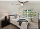 Bright bedroom featuring a large window, ceiling fan, and neutral decor at 6037 Guildford Hill Ln, Charlotte, NC 28215