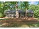 Charming single-story home with brick facade, black shutters, and mature trees surrounding the front yard at 606 Deer Creek Dr, Matthews, NC 28105