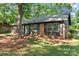 Charming brick home with a green front door and black shutters surrounded by mature trees at 606 Deer Creek Dr, Matthews, NC 28105