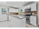 Bright kitchen featuring white cabinets, stainless steel appliances, and a granite island at 606 Deer Creek Dr, Matthews, NC 28105