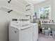 Bright laundry room with appliances, shelving, and a window at 606 Deer Creek Dr, Matthews, NC 28105