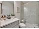 Modern bathroom with a glass-enclosed shower, gray vanity, stylish mirror and plenty of natural light at 6176 Russo Ct, Lancaster, SC 29720