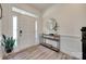 Bright foyer with wood floors, console table, round mirror, and a white front door at 6176 Russo Ct, Lancaster, SC 29720