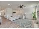A sunlit living room featuring a comfortable sectional sofa, stylish ceiling fan, and a vibrant floral rug at 6176 Russo Ct, Lancaster, SC 29720