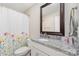 Well-lit bathroom featuring a granite countertop, decorative mirror, and floral shower curtain at 658 Morgan Rd, Albemarle, NC 28001