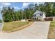Exterior view of the white home featuring a long driveway and fenced backyard at 658 Morgan Rd, Albemarle, NC 28001