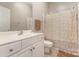 Well-lit bathroom features a vanity with sink and a shower with patterned curtain at 6912 Park Place Dr, Charlotte, NC 28262