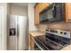 Kitchen featuring stainless steel refrigerator, microwave, stove and wooden cabinets at 6912 Park Place Dr, Charlotte, NC 28262