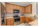 Kitchen with stainless steel appliances, wooden cabinets, and light countertops at 6912 Park Place Dr, Charlotte, NC 28262