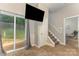 Open-concept living area features a television, access to backyard, and staircase at 6912 Park Place Dr, Charlotte, NC 28262