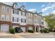 View of townhome exterior with brick accents, multiple floors, and garages at 6912 Park Place Dr, Charlotte, NC 28262