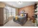 Charming bedroom featuring brick accent wall, natural light, and closet at 7216 Old Valley Way, Harrisburg, NC 28075