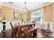 Bright dining room featuring a rustic wood table, chandelier, and large window at 7216 Old Valley Way, Harrisburg, NC 28075