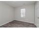 Bright bedroom featuring neutral walls, modern floors, and ample natural light through the window and a white door at 7830 Lobilia Ln, Charlotte, NC 28214