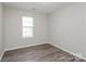 Neutral-toned bedroom with modern gray floors, a window, and clean lines, creating a serene atmosphere at 7830 Lobilia Ln, Charlotte, NC 28214