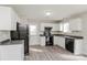 Well-lit kitchen equipped with white cabinets, black appliances, and gray countertops, creating a modern cooking space at 7830 Lobilia Ln, Charlotte, NC 28214