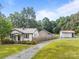 Charming cottage-style home with manicured lawn, a metal roof, a stone chimney, and blooming flowerbeds at 804 Allen Dr, Marshville, NC 28103