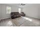Bright living room featuring wood floors, neutral walls, ceiling fan, and comfortable brown leather furniture at 804 Allen Dr, Marshville, NC 28103
