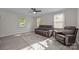 Cozy living room featuring wood floors, neutral walls, ceiling fan, and comfortable brown leather furniture at 804 Allen Dr, Marshville, NC 28103