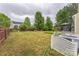 Large backyard with a green lawn, mature trees, wooden fence, and a gazebo at 8709 Barrelli Ct, Charlotte, NC 28277