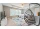 Airy bedroom with tray ceilings, ceiling fan and decorative swing chair at 8709 Barrelli Ct, Charlotte, NC 28277