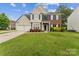 Traditional two-story home featuring a manicured lawn, brick accents, and an attached two-car garage at 8709 Barrelli Ct, Charlotte, NC 28277